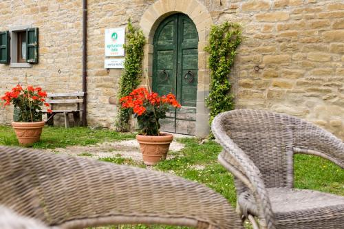 two chairs and a door with flowers in front of a building at Agriturismo L'Antico Frutto in Premilcuore