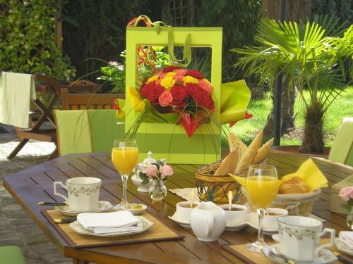 ein Tisch mit Speisen und Getränken und einem Blumenstrauß in der Unterkunft Gîtes Le Petit Nailly in Magny-les-Hameaux