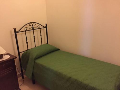a bedroom with a bed with a green bedspread at Al Centro Storico in Squinzano