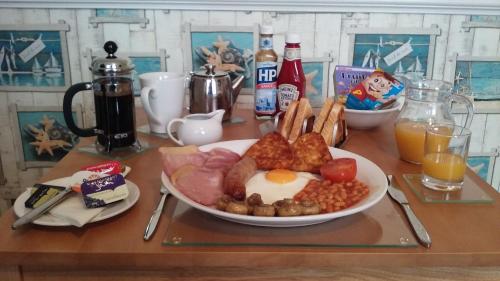 a table with a plate of breakfast food on it at Victoria Villa Guesthouse in Clacton-on-Sea