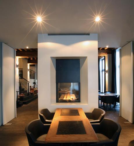 a living room with a fireplace and a table at Hotel De Groene Hendrickx in Hasselt