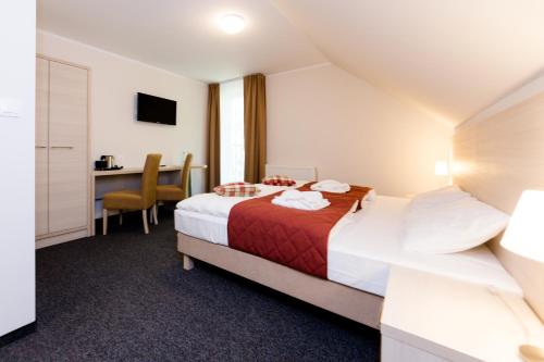 シュクラルスカ・ポレンバにあるVilla Obisのベッドとデスクが備わるホテルルームです。