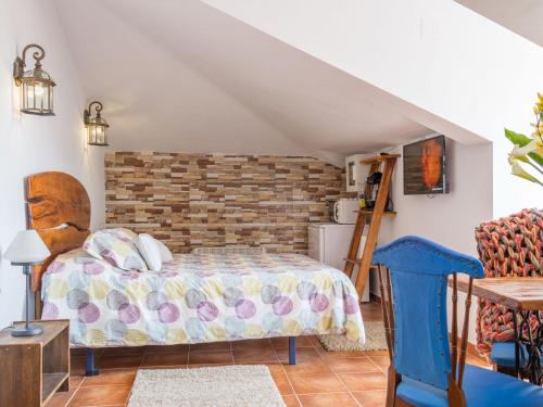 a bedroom with a bed and a brick wall at Alojamientos Mirapeñas in El Campo