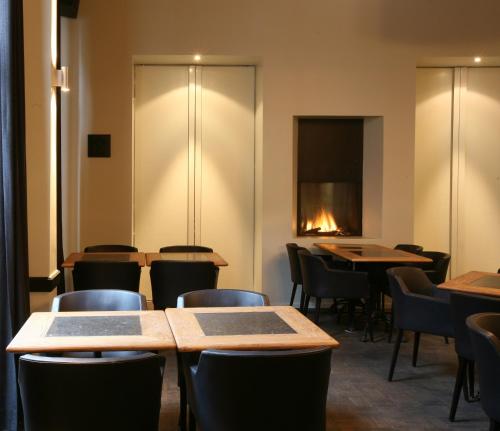 a restaurant with tables and chairs and a fire in the window at Hotel De Groene Hendrickx in Hasselt