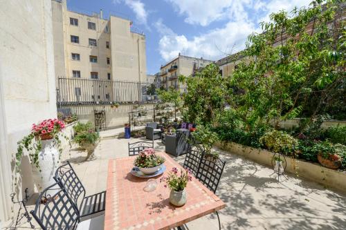 um pátio com mesa, cadeiras e plantas em Il Giardino Incantato em Matera