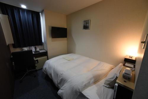 a hotel room with a bed and a window at R Hotels Inn Hokkaido Asahikawa in Asahikawa