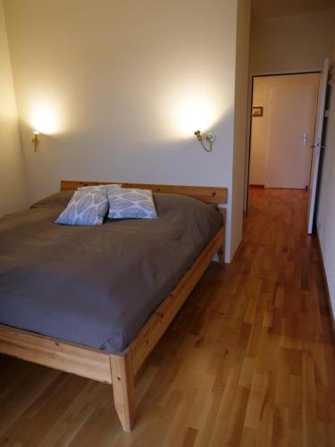 sypialnia z łóżkiem i drewnianą podłogą w obiekcie Seewohnung am Ossiacher See direkt an der Gerlitzen w Villach