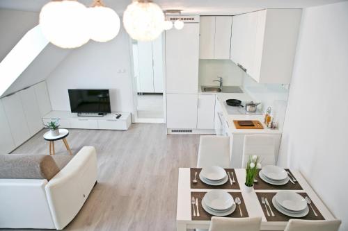 a kitchen and living room with a table and chairs at Apartments Hiša Pod Gradom in Ljubljana