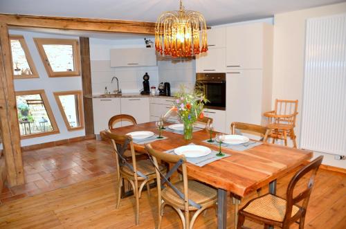 a kitchen and dining room with a wooden table and chairs at La Parenthèse in Kaysersberg