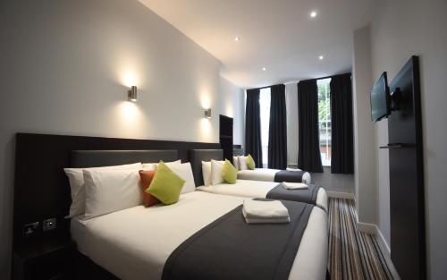 a hotel room with two beds and a television at Trebovir Hotel in London