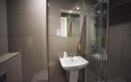 a bathroom with a sink and a glass shower at Trebovir Hotel in London