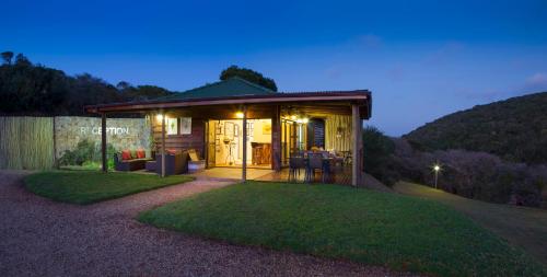 a small house with a patio and a grass yard at Thunzi Bush Lodge in Beachview