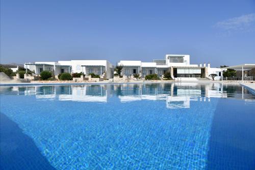 una grande piscina blu con edifici sullo sfondo di Ambelas Mare Apartments ad Ambelás
