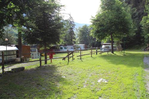 a field with a fence and tents and trees at Camping Du Parc in Pré-Saint-Didier