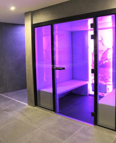 a display case with purple lights in a room at Hôtel Ginkgo - SPA Biloba in Quimper