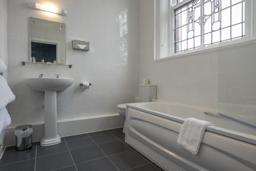 ein Badezimmer mit einem Waschbecken, einer Badewanne und einem WC in der Unterkunft Royal Clifton Hotel in Southport