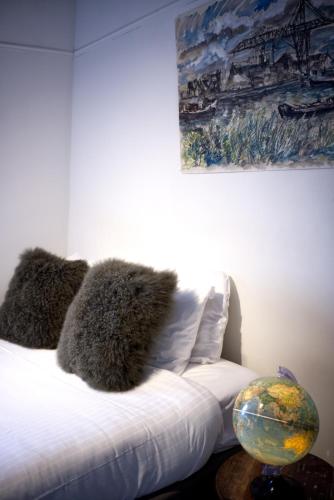 a bed in a room with a painting on the wall at Cozy Pijp Apartment Amsterdam in Amsterdam