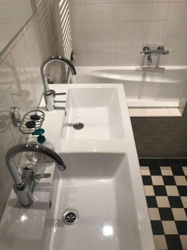 a white sink in a bathroom with a bath tub at Cozy Pijp Apartment Amsterdam in Amsterdam