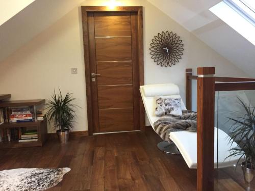 a room with a wooden door and a white chair at Waterfront House in Finstown