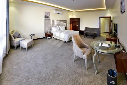 una camera d'albergo con letto, tavolo e sedie di Golden Dune Hotel Turaif a Ţurayf