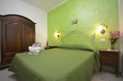 サン・ヴィート・ロ・カーポにあるtre passi dal mareのベッドルーム(緑のベッド、動物の詰め物付)