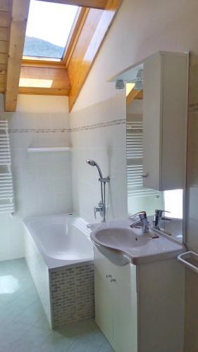 a bathroom with a sink and a bath tub at Appartamenti Arcobaleno in Molveno