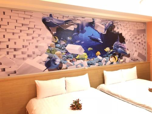 una camera con due letti e una parete con acquario di Jiahui Elevator Homestay a Città di Taitung