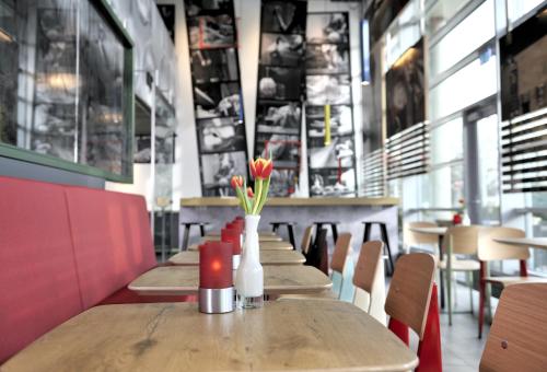 a row of tables with flowers in a restaurant at ibis Amsterdam City West in Amsterdam