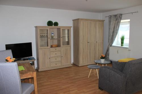 a living room with a couch and a tv and a cabinet at APARTHOTEL 1A in Zwickau