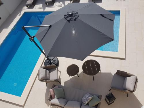 an overhead view of an umbrella in front of a pool at Apartments Villa Julija in Lumbarda