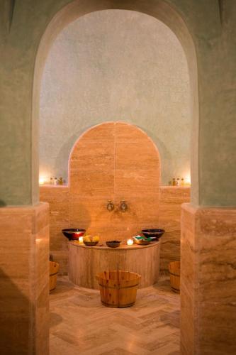 a bathroom with a tub with bowls in it at Domaine Rosaroum in Marrakech