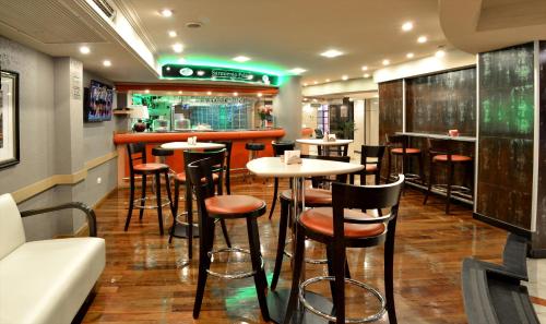 a restaurant with tables and chairs and a bar at Sarmiento Palace Hotel in Buenos Aires