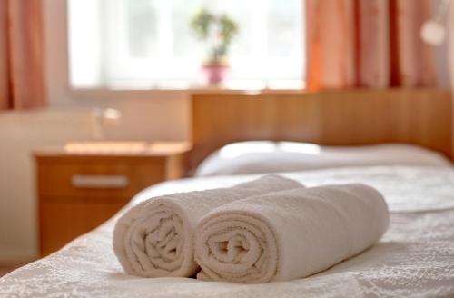 a stack of towels sitting on top of a bed at Penzion Tillerova vila in Lázně Bohdaneč