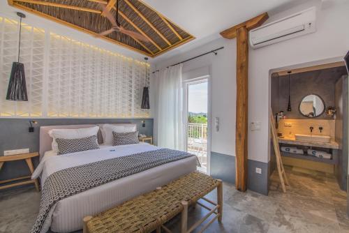 a bedroom with a large bed and a bathroom at Antigoni Seaside Resort in Ormos Panagias