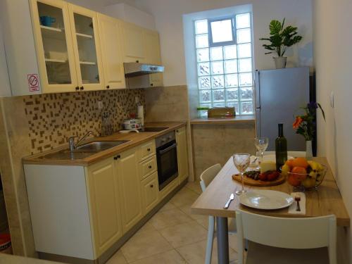 a kitchen with yellow cabinets and a table with a bowl of fruit at Apartments Vincent in Kastav