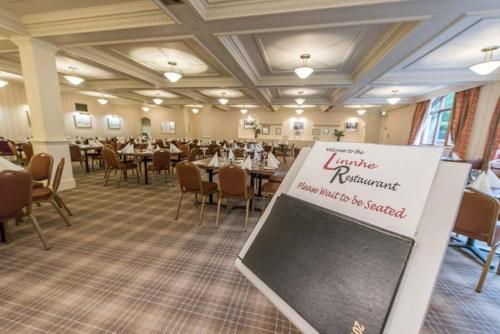 a banquet hall with tables and a sign in the middle at Alexandra Hotel in Fort William