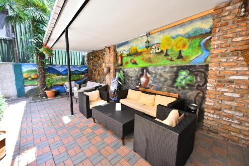 a patio with couches and a wall with a mural at Hotel Phaliashvili in Batumi
