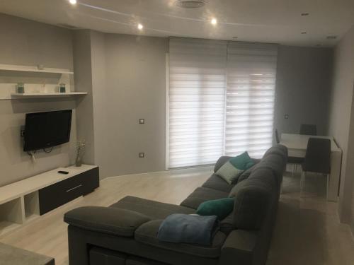 a living room with a couch and a flat screen tv at Apartamento Ausonio 2 dormitorios in Merida