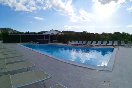 a large swimming pool with lounge chairs at Fontana La Pietra in Pisticci