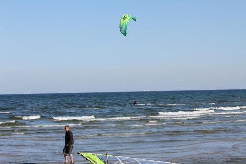 a man standing on the beach flying a kite at Nivå Camping & Cottages in Nivå