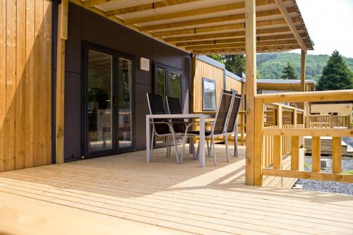 a deck with a table and chairs on a house at Tornade in Dirbach