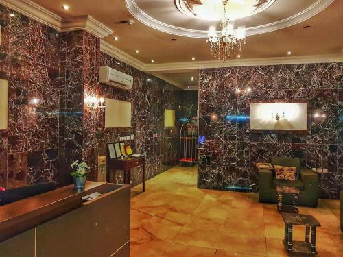 a lobby with black marble walls and a chandelier at White Beach Hotel Suites in Rabigh