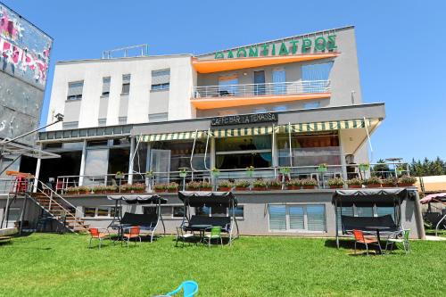 a building with chairs in the grass in front of it at Vu-Dent Apartments in Gevgelija
