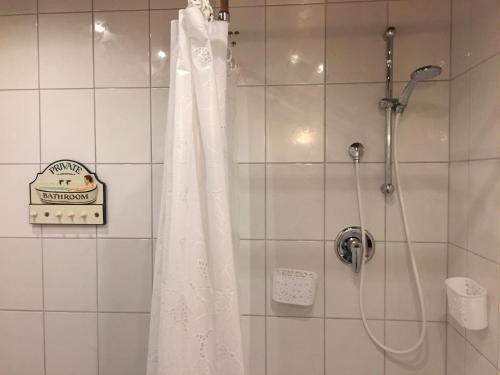 y baño con ducha con cortina blanca. en le mignon en Illingen