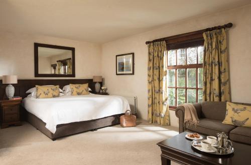 a bedroom with a bed and a couch and a window at Bushmills Inn Hotel & Restaurant in Bushmills