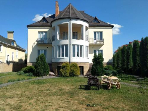 a large white house with a table in front of it at Хостел Lutsk G84 in Lutsk