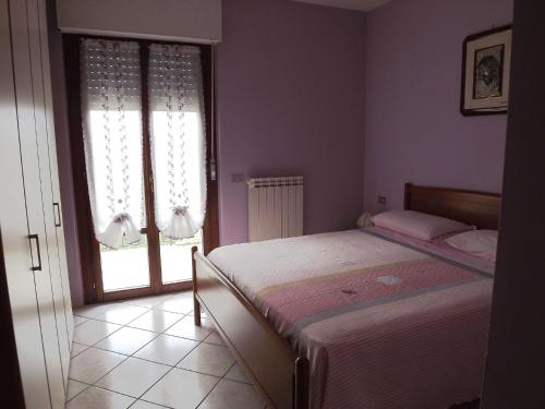 マルティンシクーロにあるAppartamenti Mimosaのベッドルーム1室(ベッド1台、大きな窓付)