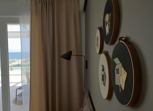 a room with clocks on the wall and a lamp at Fiume Luxury Apartments near the SEA in Monopoli