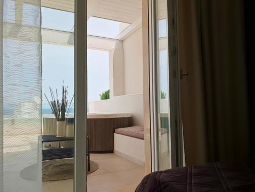 a bedroom with a view of the ocean through a glass door at Fiume Luxury Apartments near the SEA in Monopoli