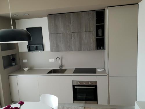 a kitchen with white cabinets and a sink at Fiume Luxury Apartments near the SEA in Monopoli